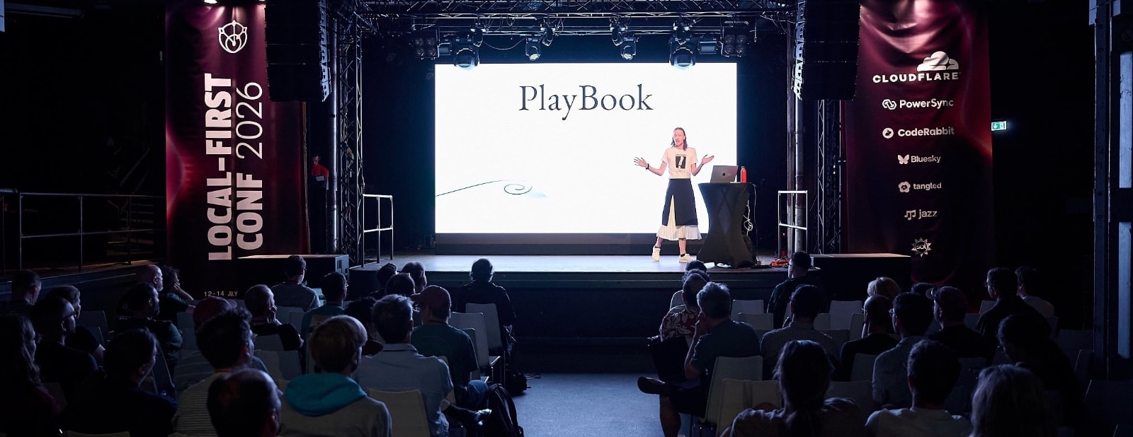 A photo of Ivy on stage introducing PlayBook to a seated audience.