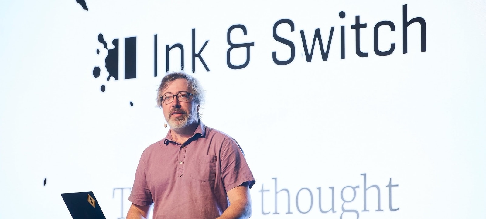 A close-up photo of Peter, standing in front of a slide that says "Tools for Thought".